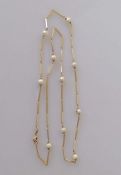 A 9ct yellow gold and pearl decorated neck chain, 56 cm, hallmarked, 9.5g