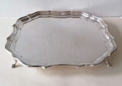 A George V silver tray of square form with pie-crust border on four splayed hoof feet