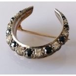 A sapphire and diamond crescent-shape brooch on yellow gold, the largest stones approximately 0.10 c