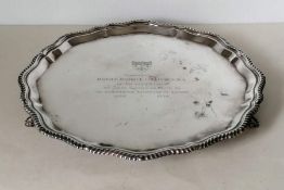 An octagonal silver tray with rope-twist border on three feet with engraved dedication