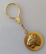 A yellow gold keyring with raised lion profile disc, hallmarked for Asprey & Co. Ltd., London 1994