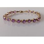 An amethyst and yellow gold line or tennis bracelet with lobster clasp