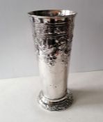 An Edwardian silver cylindrical vase with embossed decoration on a stepped base