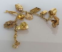 A yellow gold bracelet with oriental charms, all stamped 14k, 16.9g