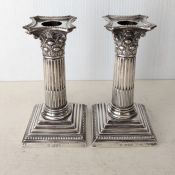 A pair of late Victorian silver candlesticks in the form of Corinthian columns, stepped bases