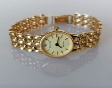 An ladies Accurist Gold quartz dress watch with oval champagne dial, baton markers