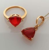 A trilliant-cut ruby ring with diamond decoration by Iliana, on a yellow gold claw setting
