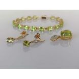 A peridot and gold parure comprising line or tennis bracelet, 16 cm, with matching pendant