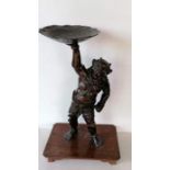 A Japanese bronze figure of Oni, modelled supporting a lotus-form candle stand, moulded signature