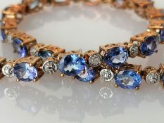 An indigo opal line or tennis bracelet, the oval stones (5 x 4mm) interspersed with diamonds