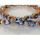 An indigo opal line or tennis bracelet, the oval stones (5 x 4mm) interspersed with diamonds