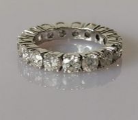 A diamond eternity ring on a white gold claw setting, total diamond weight 3.60 carats, colour D-E