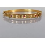 A late Victorian Etruscan-style ruby and diamond hinged gold bangle, interior 65mm W, hallmarked 9ct