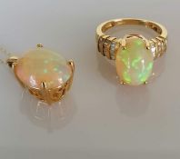 An oval opal cabochon ring on a 14ct gold claw setting with baguette diamond decoration to the shoul