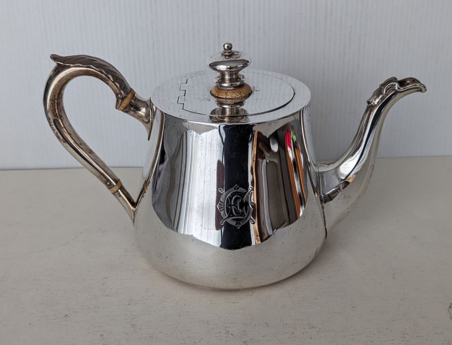 A Victorian silver teapot with acanthus leaf decoration, ivory insulators, crested