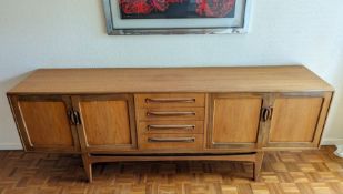 A G-Plan Fresco teak sideboard, centred by four graduated drawers flanked to either side by twin cup