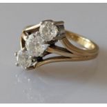 A three-stone diamond ring in a gold claw setting, centrally set with one old European-cut diamond