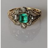 A 19th century emerald and diamond cluster ring on a gold setting, the square-cut emerald