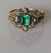 A 19th century emerald and diamond cluster ring on a gold setting, the square-cut emerald 