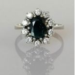 An oval sapphire and diamond cluster ring on a white gold setting, the sapphire 9 x 6mm