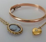 A Victorian yellow gold heart locket pendant and chain, 40 cm; an oval cameo gold pendant