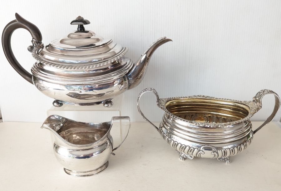 A George III silver teapot with gadrooned rim, acanthus leaf decoration to spout, ebonised handle