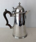 An Edwardian silver coffee pot of George III design, the domed cover with turned finial