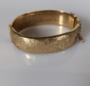 A 9ct yellow gold bangle with etched decoration, wax filled, hallmarked for Deakin & Francis Ltd