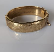 A 9ct yellow gold bangle with etched decoration, wax filled, hallmarked for Deakin & Francis Ltd
