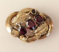 A Victorian gold oval brooch with three graduated amethysts and carved leaves, 4 x 3 cm, unmarked