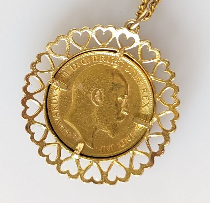 An Edwardian gold half sovereign, 1909, on a 9ct mount and chain, 10g