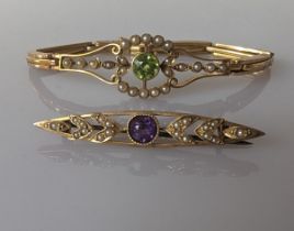 An Edwardian peridot and seed pearl bracelet on a gold bracelet setting, articulated links