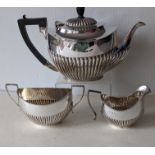 An Edwardian silver teapot with fluted decoration, ebonized knop/handle
