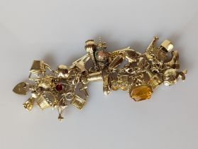 A gold charm bracelet, all hallmarked 9ct, 65g