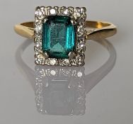 An Art Deco-style baguette-cut emerald and diamond ring on an 18ct yellow gold setting