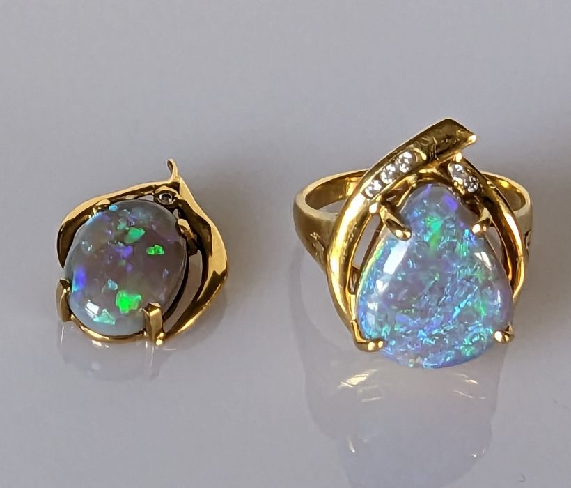 An Australian black opal ring in an 18ct gold claw setting with diamond decoration, 15 x 12mm