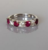 An 18ct white gold ruby and diamond seven-stone half-hoop eternity ring in a claw setting