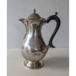 A Victorian silver coffee pot of bulbous form with ebonized handle, fluted decoration by Dobson 