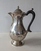 A Victorian silver coffee pot of bulbous form with ebonized handle, fluted decoration by Dobson 