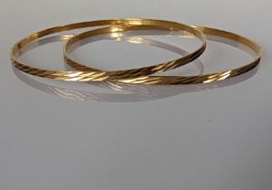 Two yellow gold bangles with etched decoration, Egyptian hallmarks for 18ct, 10.5g