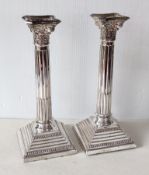 A pair of silver corinthian-style candlesticks with sconces on stepped bases by Hampton Utilities