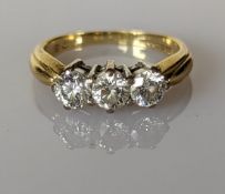 A three-stone diamond ring on an 18ct yellow gold tapering shank, size J