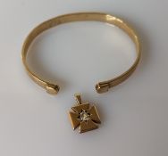 A yellow gold torc bangle, 55mm, unmarked but tests for 9ct, 15.2g and a gold pendant with diamond d