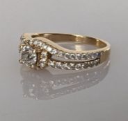 A solitaire diamond ring with split shoulder shank, decorated with diamonds to both sides