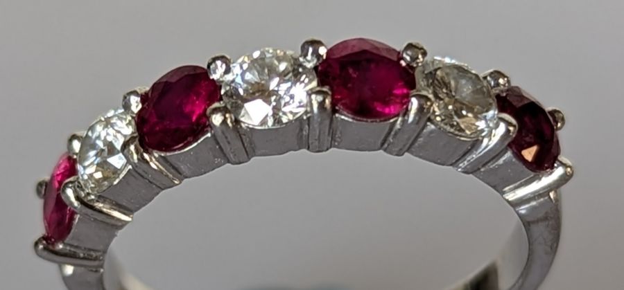 An 18ct white gold ruby and diamond seven-stone half-hoop eternity ring in a claw setting - Image 3 of 5
