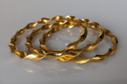 Three yellow gold rope-twist bangles, 65mm, each stamped 916, 40g (3)