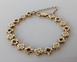 A 9ct gold bracelet with diamond and garnet floral design, hallmarked, 15.5 cm, 20g