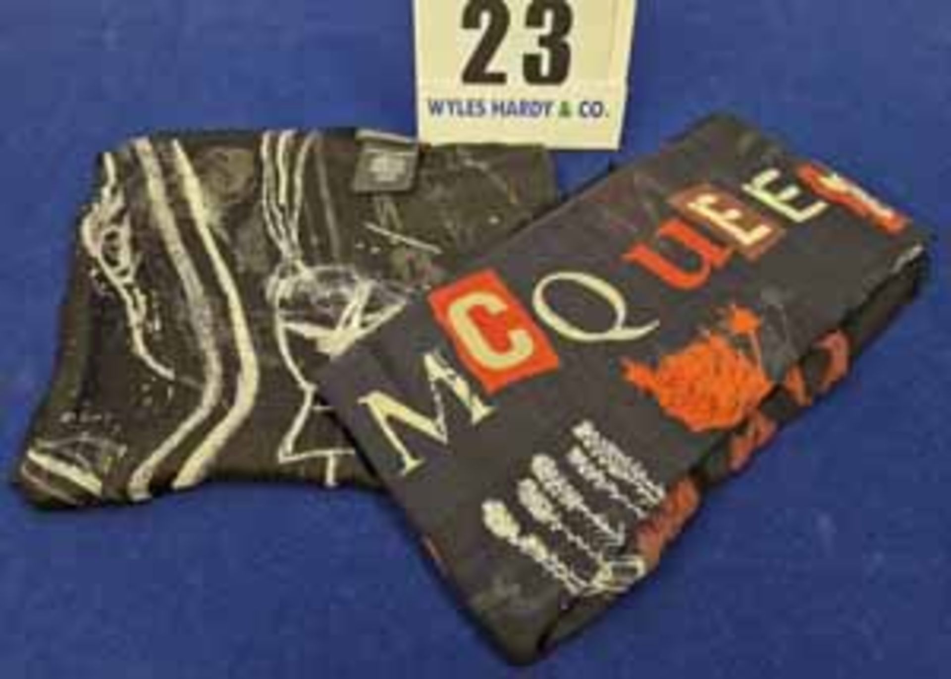 A Set of Two ALEXANDER McQUEEN Scarves. - A Black with Classic White Skull detailing - A Blue with