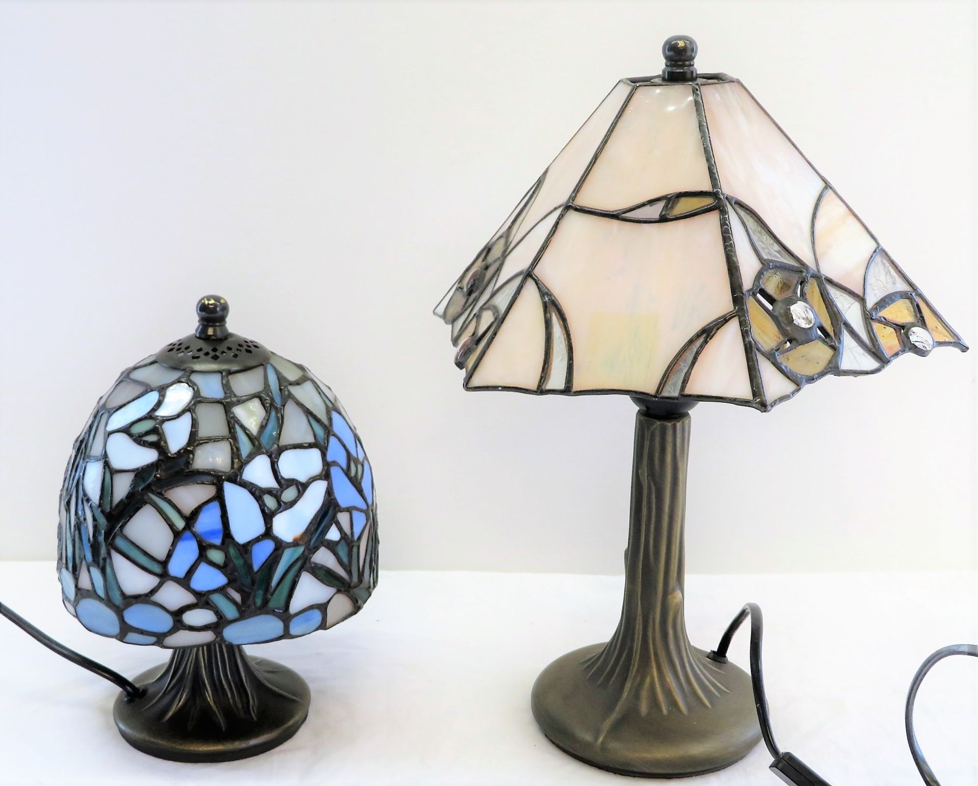 2 Tiffany-Stil Tischlampen, Schirme mit farbiger Bleiverglasung, Füße vegetabil modellierter Messin