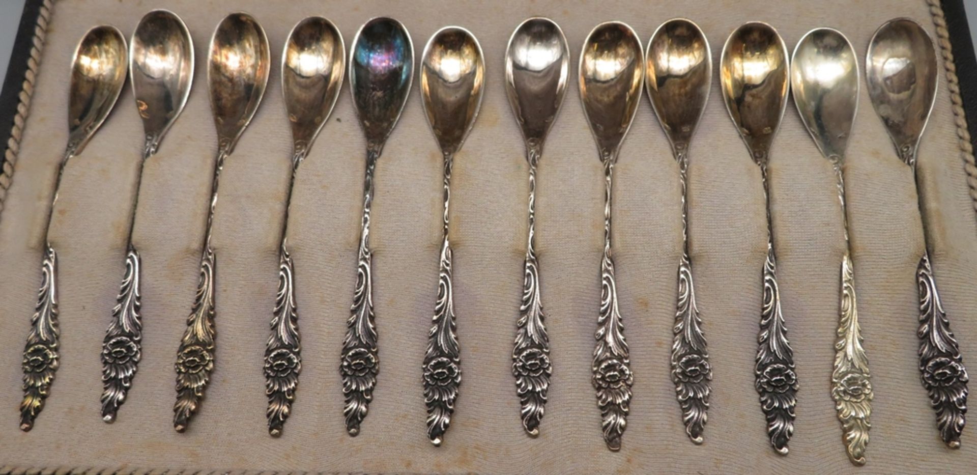 12 Teelöffel, Silber 835/000, punziert, 97,3 g, Stielenden mit reliefierten Blumenmotiven, in Schat